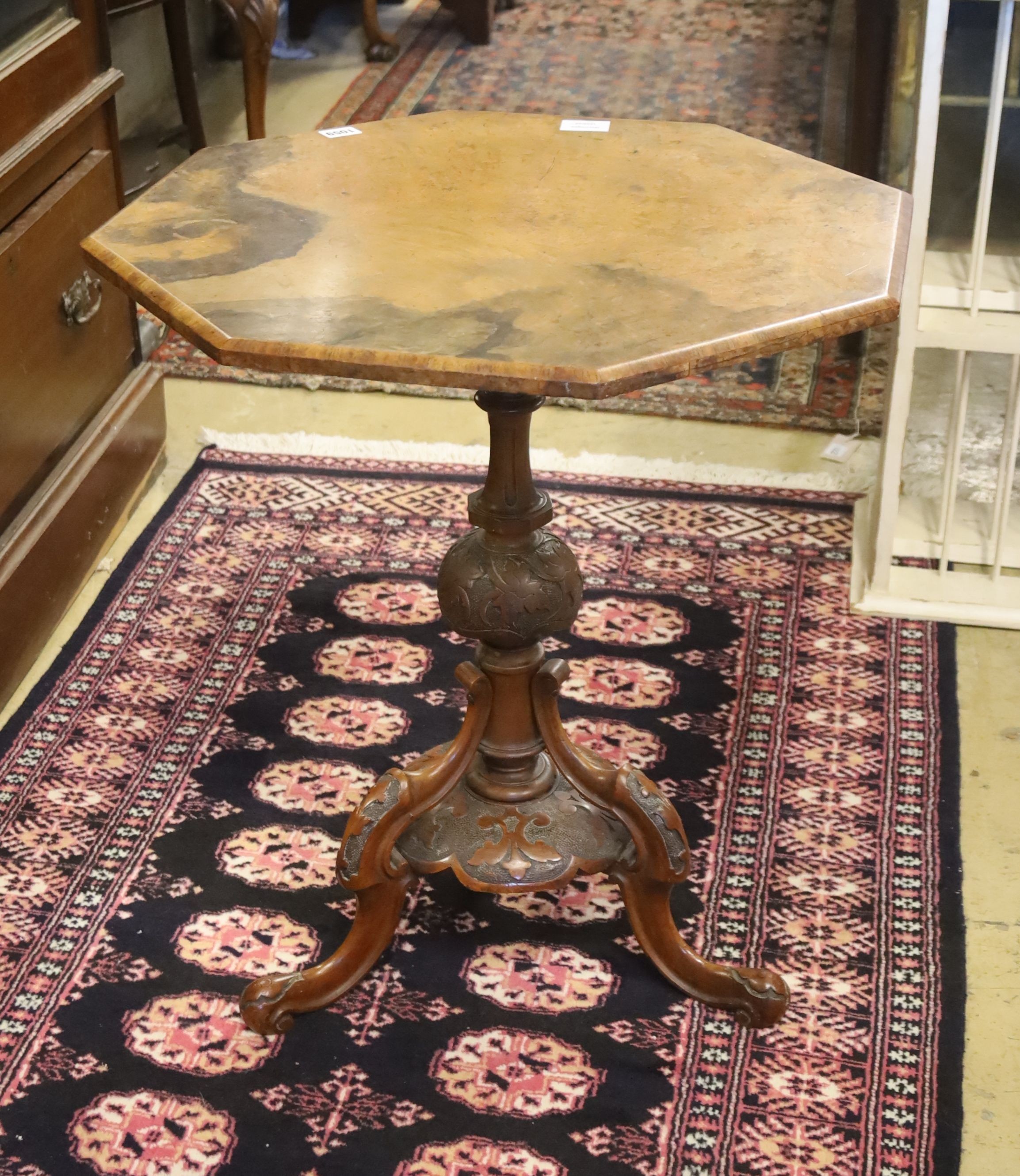 A Victorian burr walnut octagonal topped tea table, raised on leaf carved pillar and open scrolled cabriole tripod base, width 58cm, height 65cm